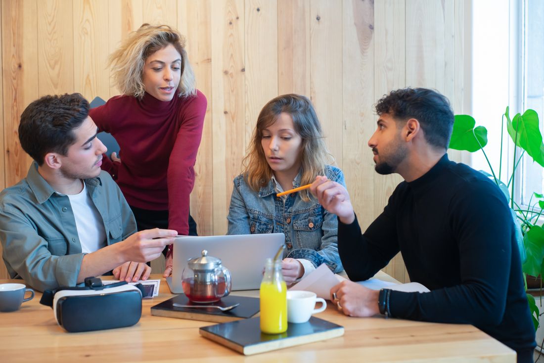 A team collaborating around a laptop.
